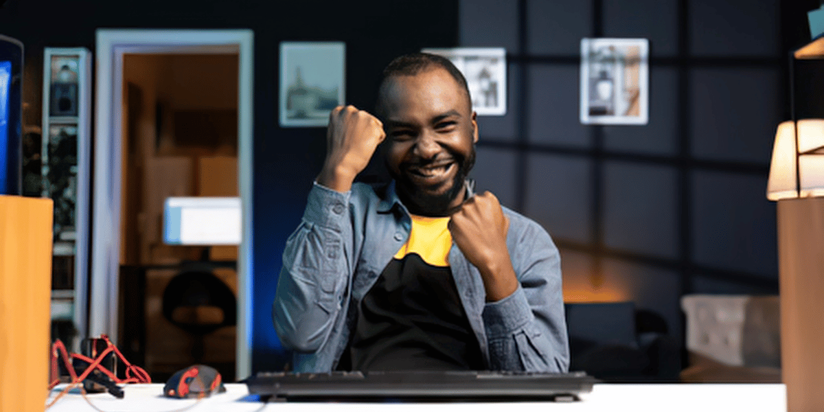 Professional celebrating a successful workflow while working at a computer.