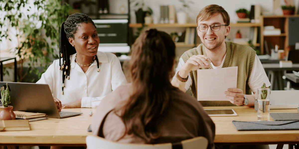 Business professionals interviewing a candidate during a hiring meeting.
