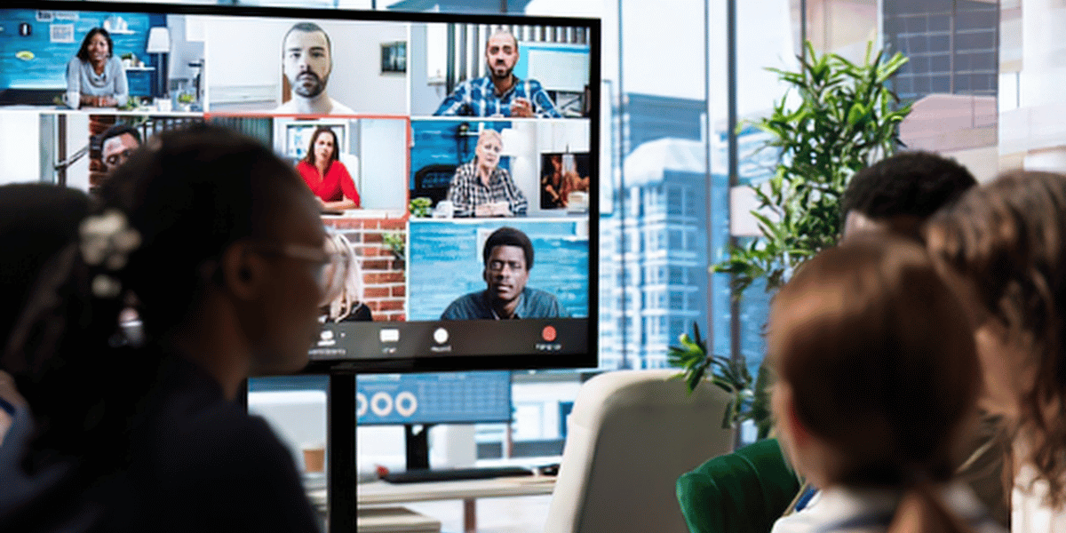 Business team collaborating with remote specialists during a video meeting.
