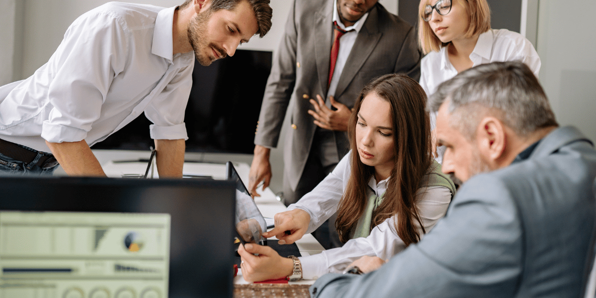Business team reviewing customer data and analytics together on computer screens.