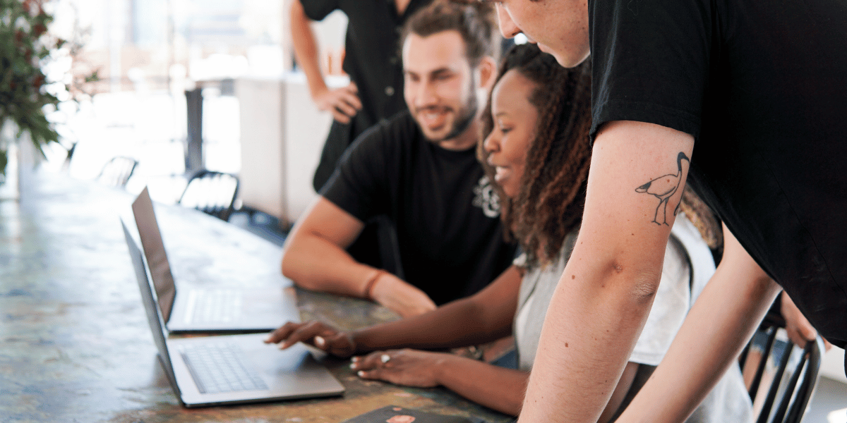 Business team collaborating on a laptop during a website development session.