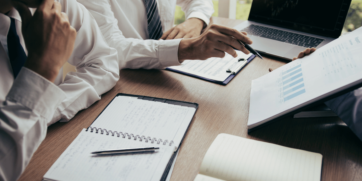 Business professionals reviewing charts and financial documents during a meeting.